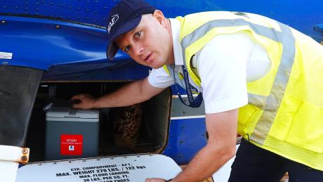 Pilot Wim Hobo loads vaccine on a MAF plane