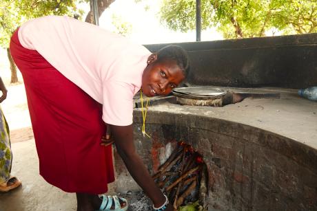 A girl cooks food at New Life School where Nyabrom and her siblings have meals.
